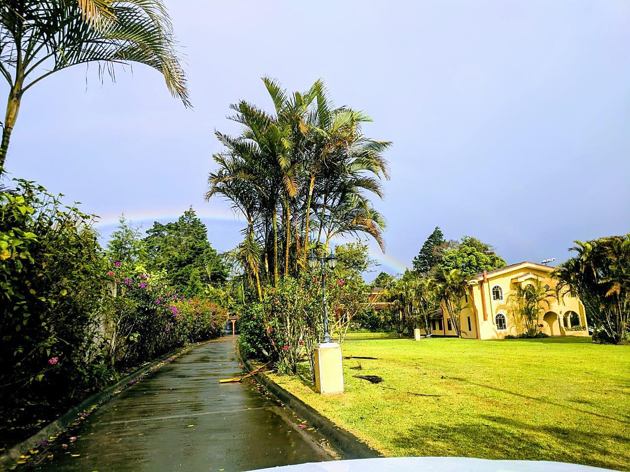 Entrada privada con jardines y palmeras